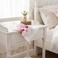 Fleur Face Towel on white wooden bench with floral pattern beside vase in bedroom setting