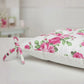 Floral-patterned cushion with pink roses on a white background, featuring detailed product view.