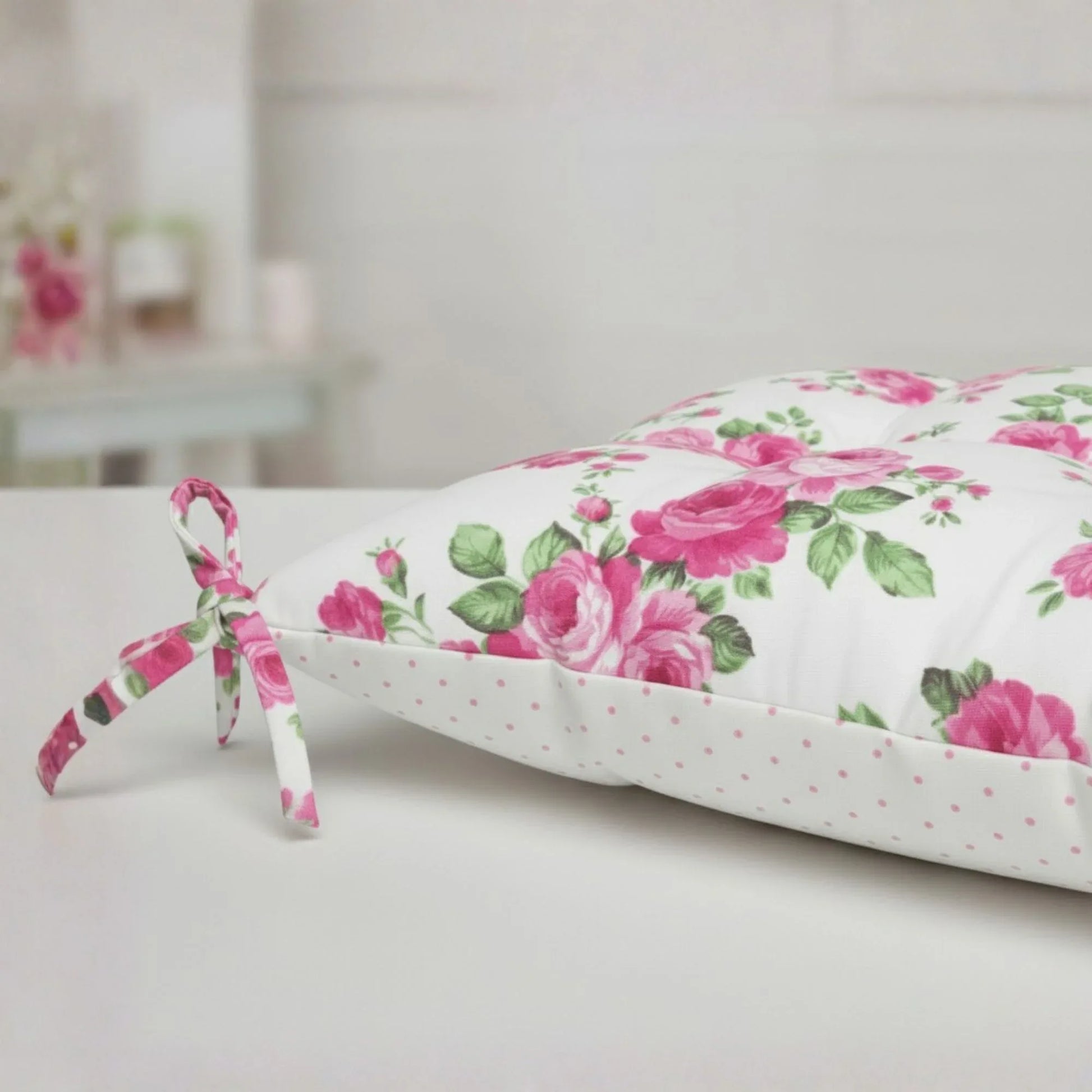 Floral-patterned cushion with pink roses on a white background, featuring detailed product view.