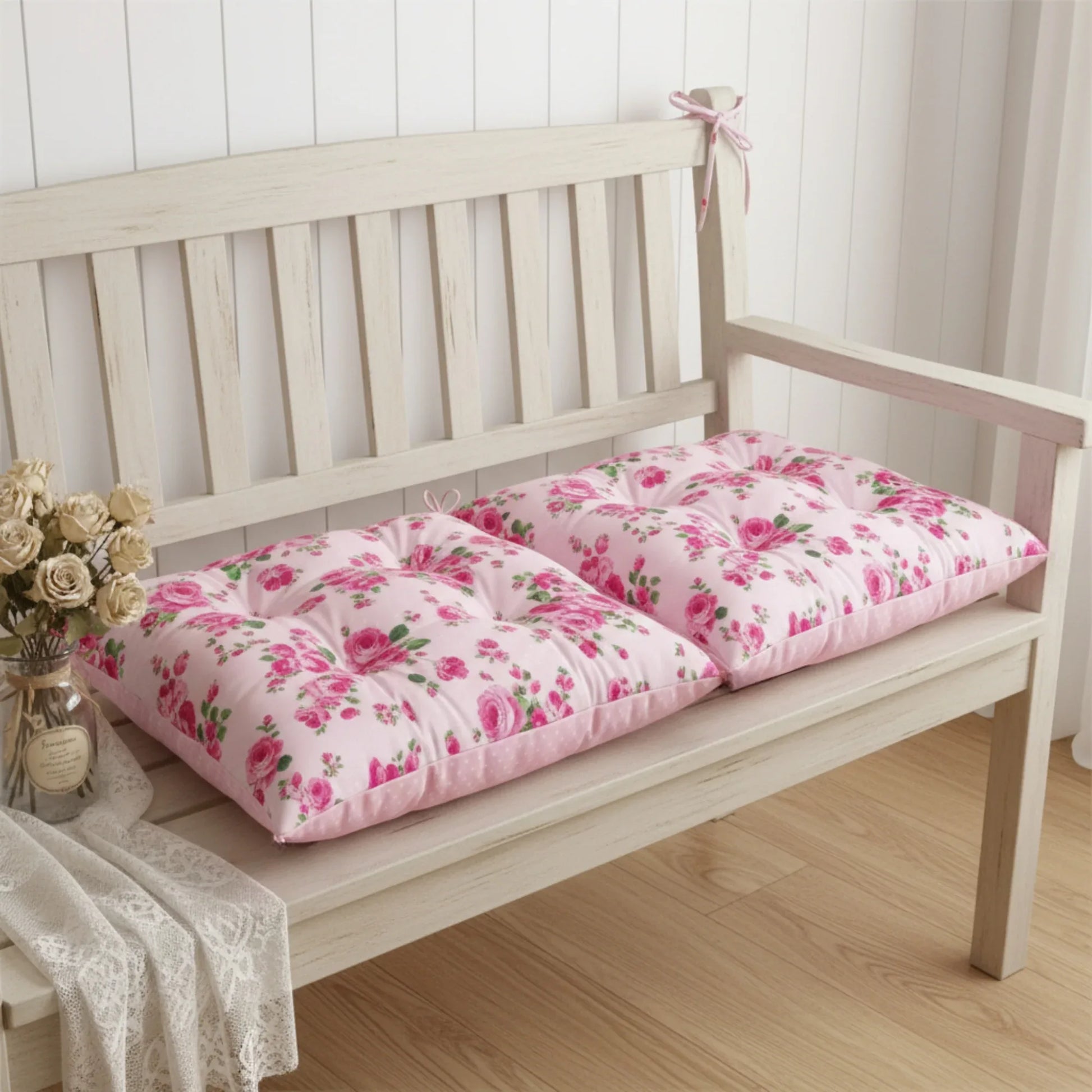 Floral cushions on a wooden bench with a vase of flowers on a light wood floor.
