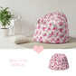 Floral-patterned bean bag chair in a room with a plant and small table.

