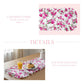 Floral table runner with pink and green flowers on a white background, displayed on a table with food.
