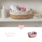 Wicker basket with floral liner containing rolled towels on a shelf with toiletries.