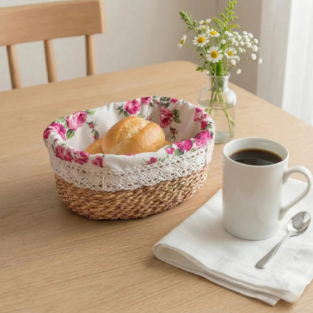 Floral-patterned bread basket with a loaf of bread on a table with a cup of coffee and flowers.