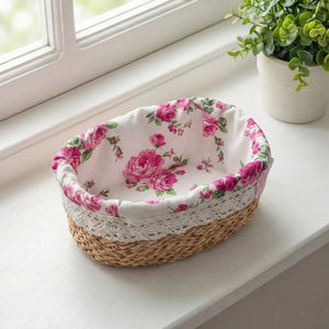 Wicker basket with floral fabric liner on a windowsill with a plant.