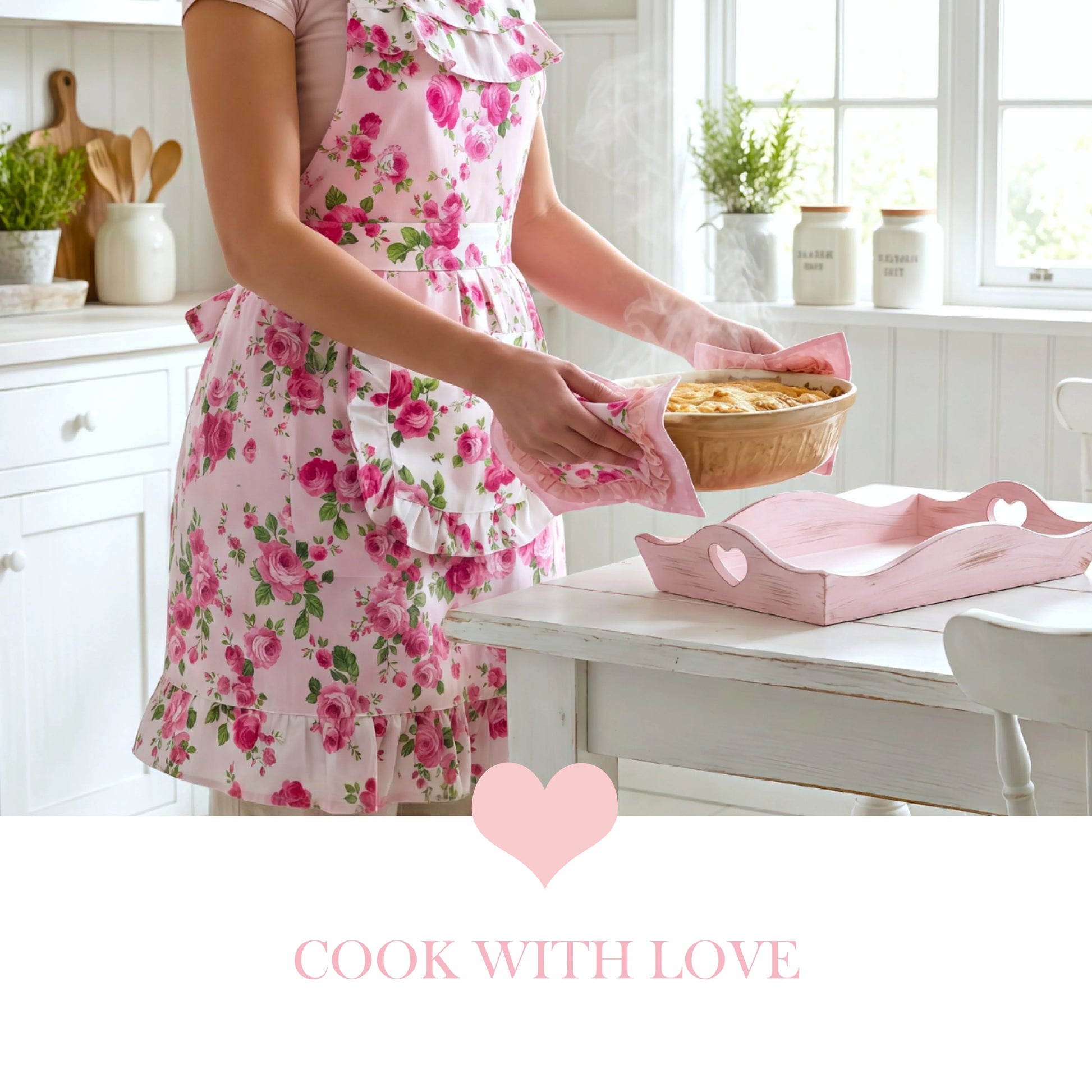 Person in a pink floral apron holding a steaming dish above a pink heart tray and the text "COOK WITH LOVE."