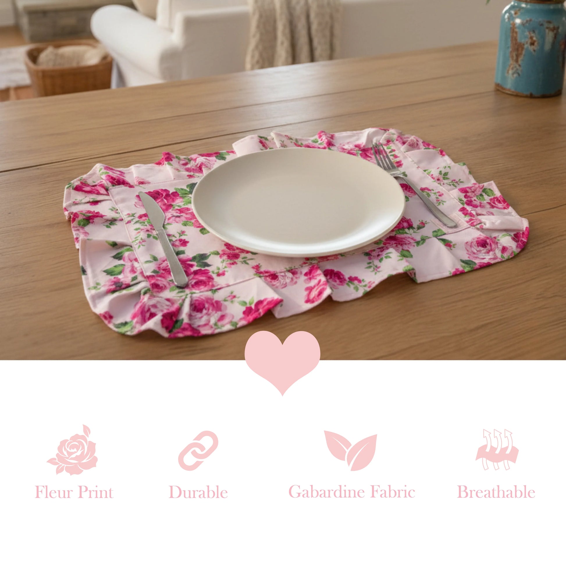 White plate on a pink floral ruffled placemat above icons for fleur print, durable, gabardine fabric, and breathable.