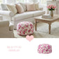 Floral ottoman in a living room setting with a couch and coffee table.