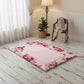 Floral rug on a wooden floor with a rocking chair and lamp in the background.