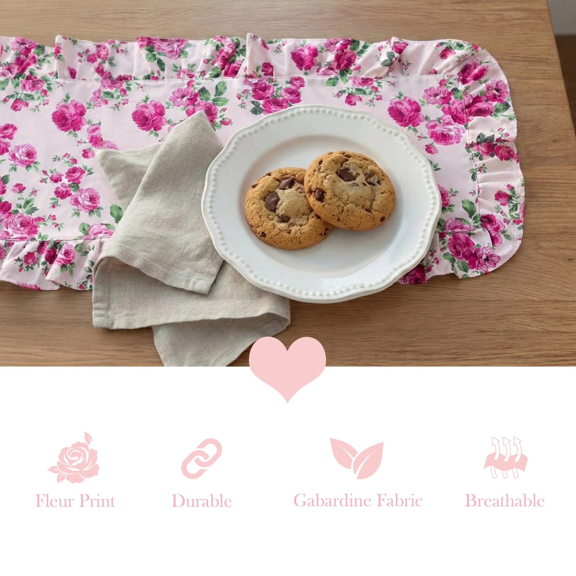Chocolate chip cookies on a white plate over a pink floral ruffled table runner with product feature icons below.