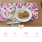 Floral table runner with a plate of cookies on a wooden table