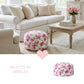 Fleur print round pouf ottoman in a living room with a white sofa and a wooden coffee table.
