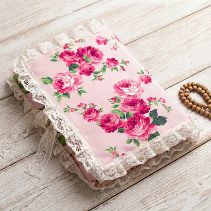 Floral fabric with pink roses on a wooden surface