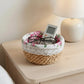 Woven basket with floral fabric on a nightstand next to a lamp