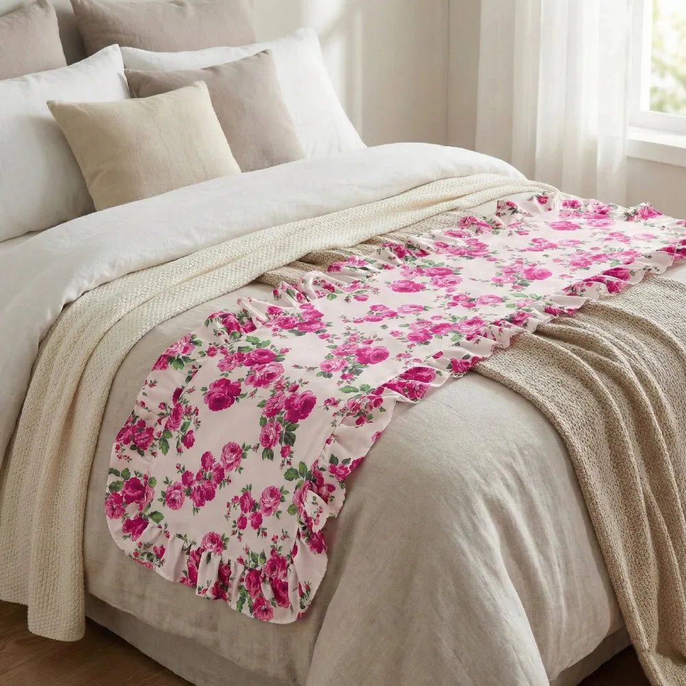 Fleur table runner on a bed with beige bedding