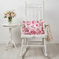 Fleur Ruffled Rectangular Cushion with Filling pale pink on white rocking chair with floral blanket beside small round table
