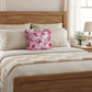 Fleur Ruffled Square Cushion with Filling in pale pink styled on wooden bed with beige bedding bedroom décor scene