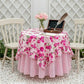 Fleur Table Cover round table with pink floral design, vase of flowers and writing set outdoor setup