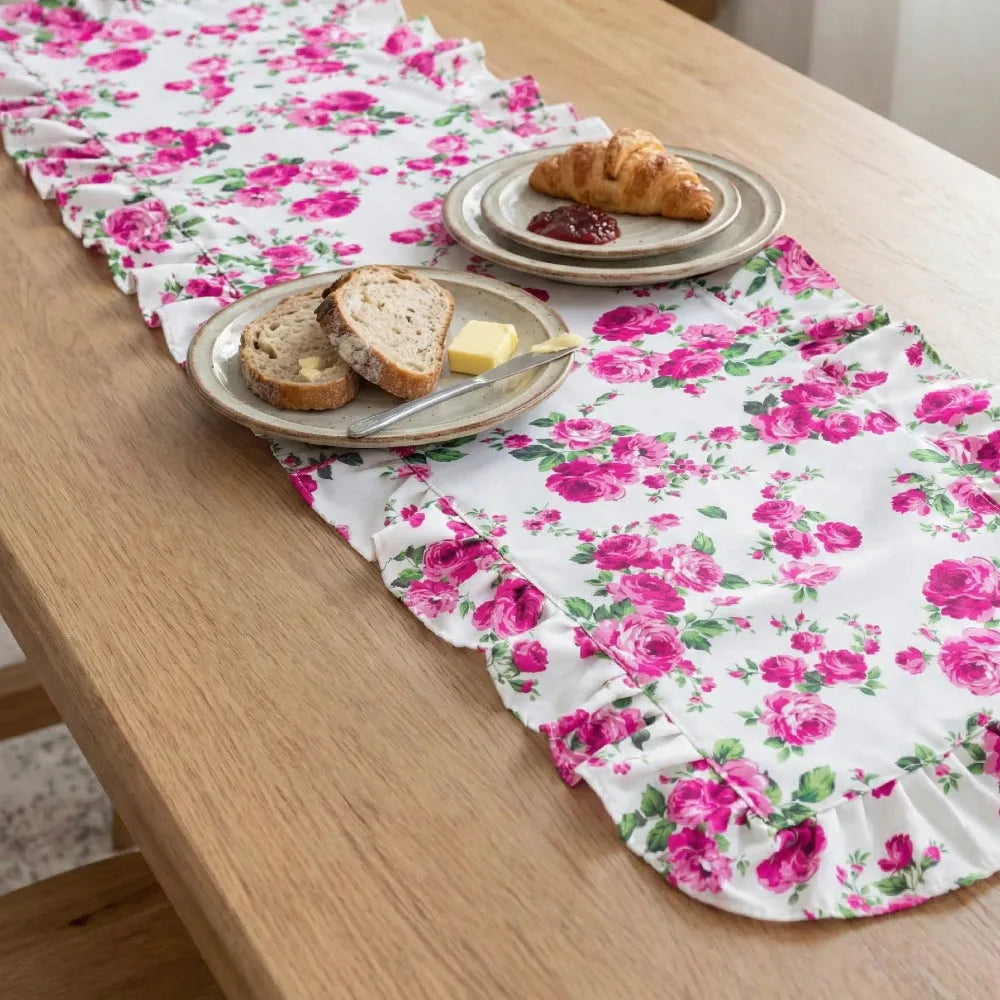 Fleur table runner on a wooden table with plates of bread and butter.