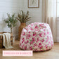 Floral bean bag chair in a room with plants and a wooden crate.