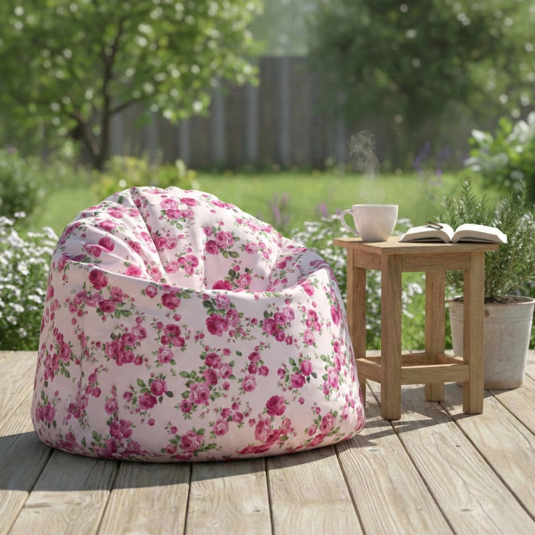 Floral bean bag chair on a wooden deck with a small table and plants in the background.