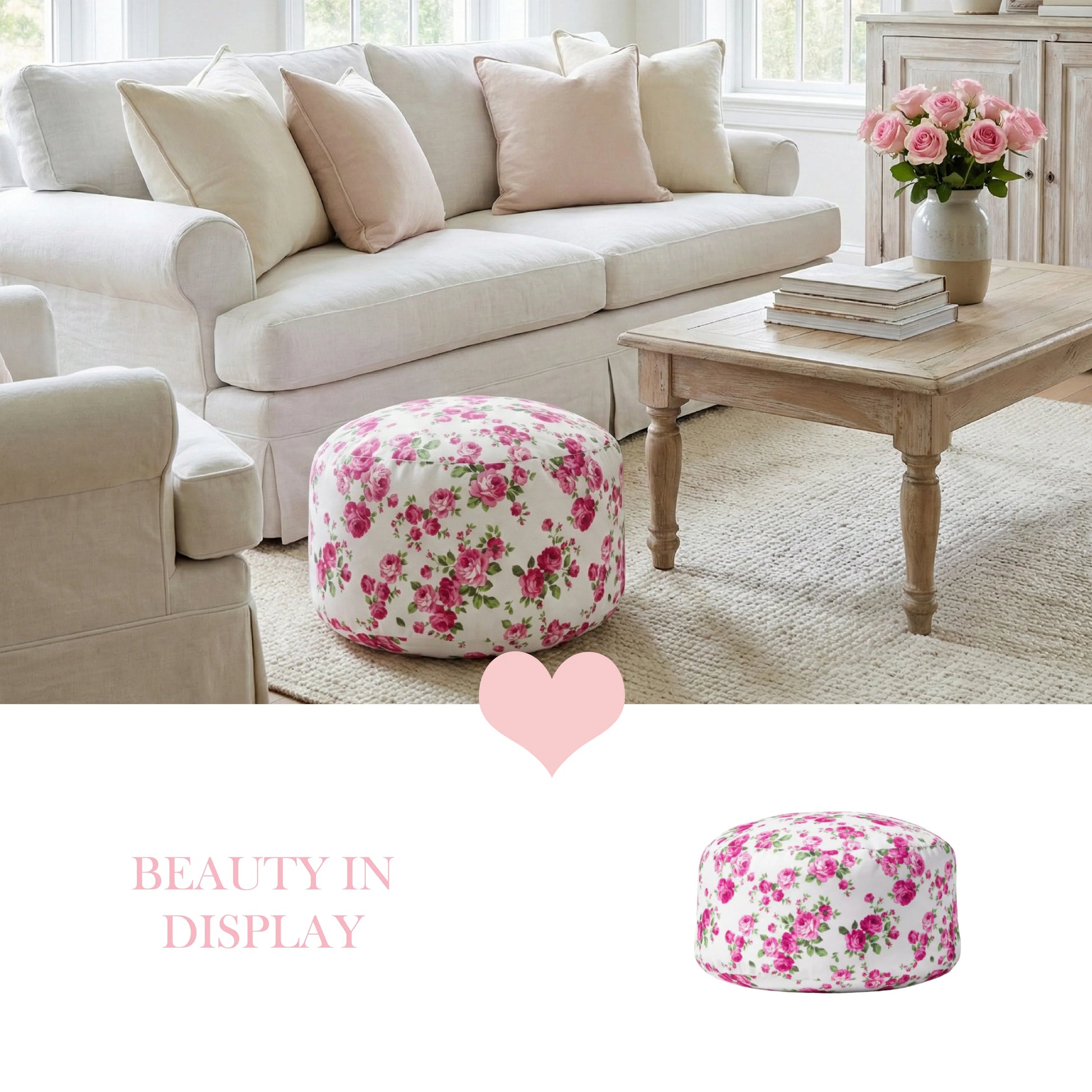 A pink rose fleur pouf on a cream rug in a bright living room with a white slipcovered sofa and a light wood coffee table with fresh roses.