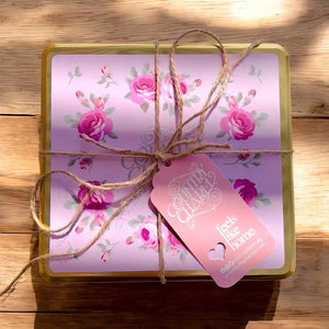 Gift box with floral design and pink tag on a wooden surface