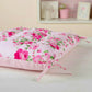 Floral-patterned cushion on a wooden surface with a soft pink background