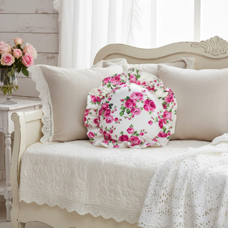Floral pillow on a beige sofa with a vase of flowers in the background
