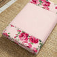 Floral-patterned pink fabric prayer rug roll on a textured surface