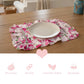 Floral placemat with a plate and cutlery on a wooden table, with product features listed below.