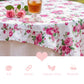 Floral tablecloth with pink roses on a table setting with a glass of tea.
