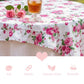 Floral tablecloth with pink roses on a table setting with a glass of tea.