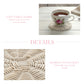 Teacup with floral design on a woven coaster on a wooden table, with text about cozy table charm and bamboo wood craft.