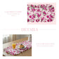 Floral table runner with pink and green flowers on a white background, displayed on a table with food.