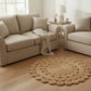 Halfa Flower-Shaped Rug placed beside beige sofa in living room with natural woven floral design