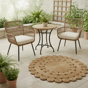 Outdoor patio set with two chairs, a table, and a round jute rug on a tiled floor.