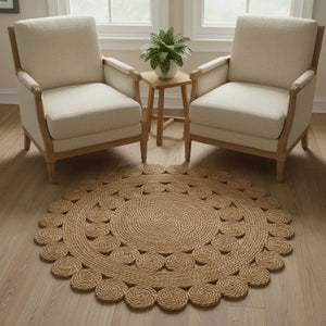 Round rug in front of two beige armchairs with a small wooden table and plant in a bright room.