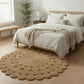 Bedroom with a round woven rug, bed, and wooden bench.
