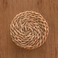 Round woven trivet on a wooden surface