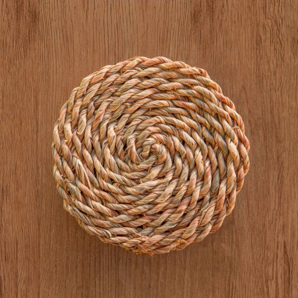 Round woven trivet on a wooden surface