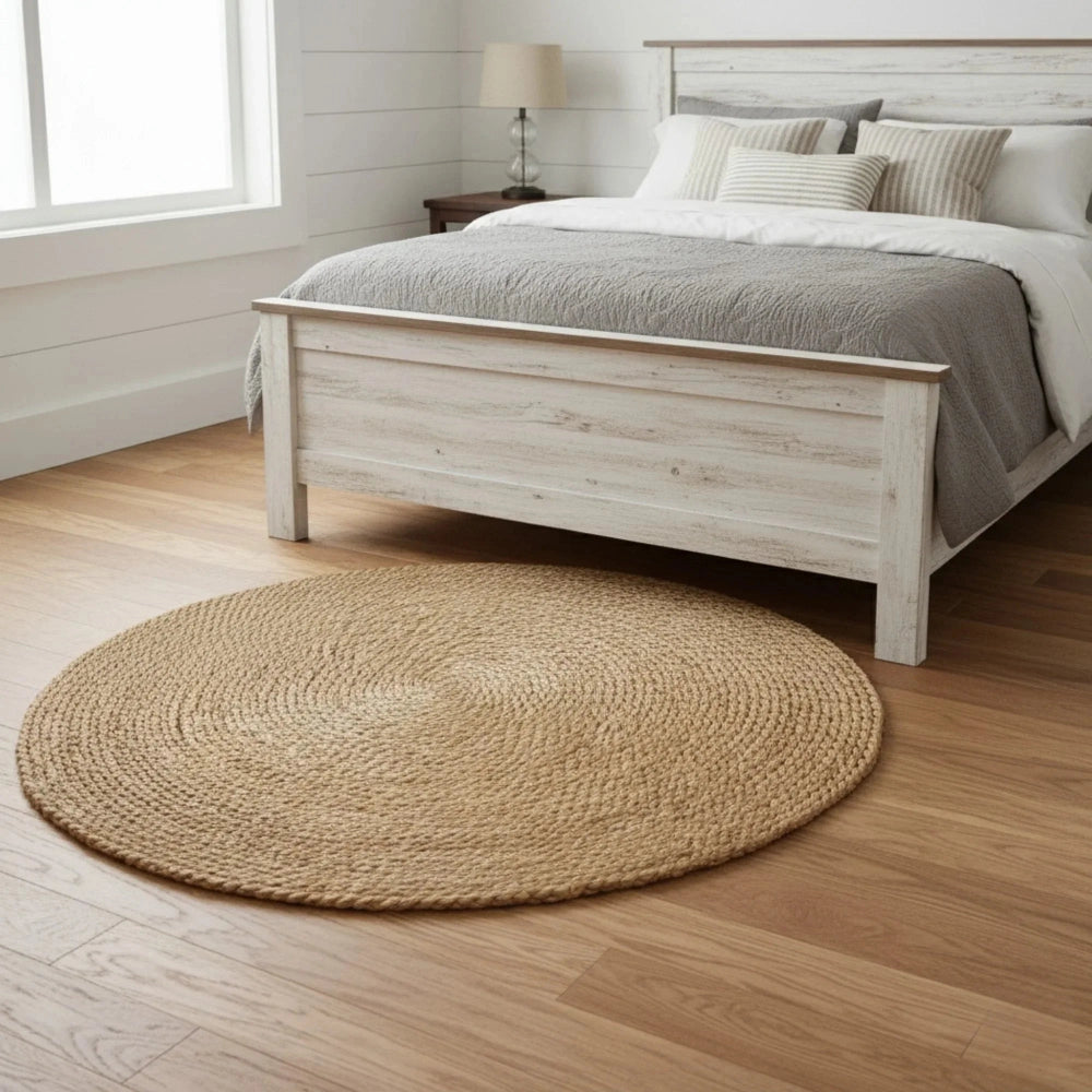 Bedroom with wooden bed frame, round woven rug, and lamp.