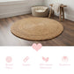 Round braided halfa rug on a wooden floor with a small wooden stool and pet bed in the background.