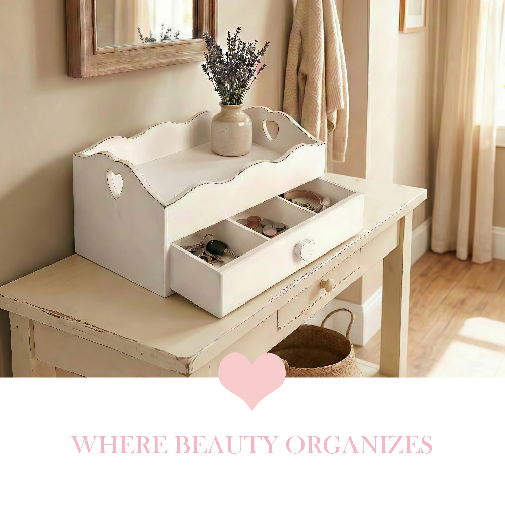 A white wooden Heart Cut-Out Flatware Tray with three divided drawer compartments for jewelry and key storage, styled on a console table under a mirror with "Where Beauty Organizes" text.