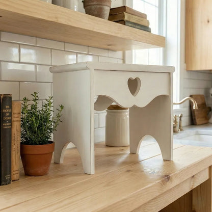 Heart Cut-Out Countertop Table in white wood displaying books and plants