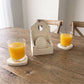 Heart-Shaped Coasters with Wooden Holder holding two orange juice glasses on natural wood table for home serving
