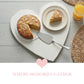 Heart-Shaped Serving Board with sliced cake, dessert plate, and orange juice on wooden table