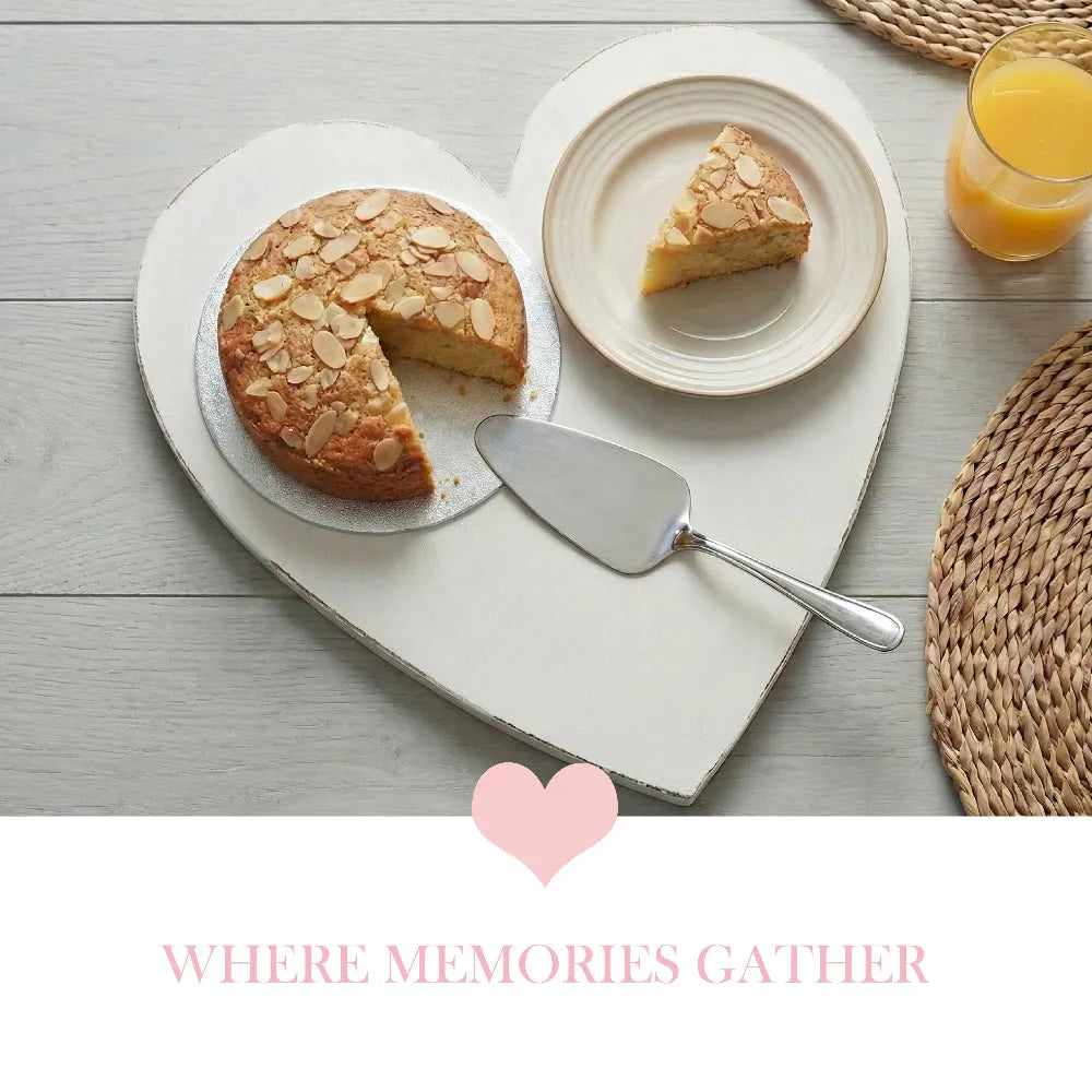 Heart-Shaped Serving Board with sliced cake, dessert plate, and orange juice on wooden table