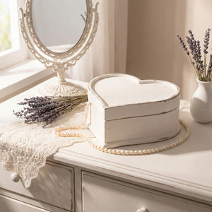 Heart-shaped wooden box on a dresser with lavender and a mirror in the background