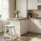 Heart-Shaped Wooden Stool placed beside rustic kitchen island with cream cabinets, wildflowers, and wooden cutting boards